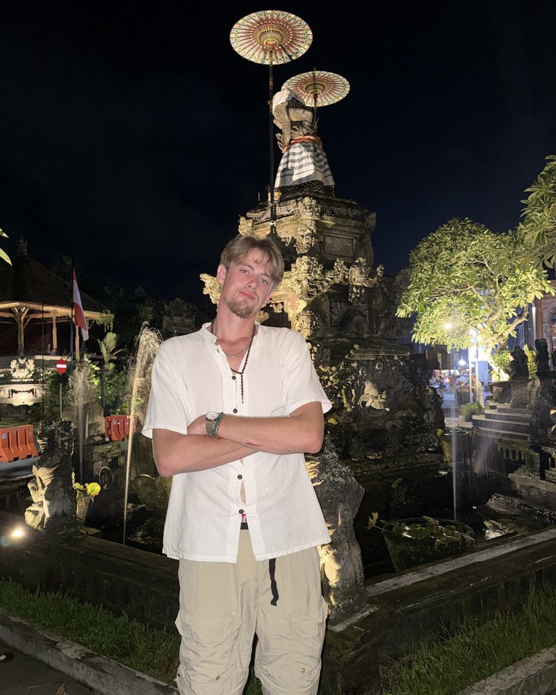 Founder of Hoss Online, standing in front of an illuminated temple fountain at night.